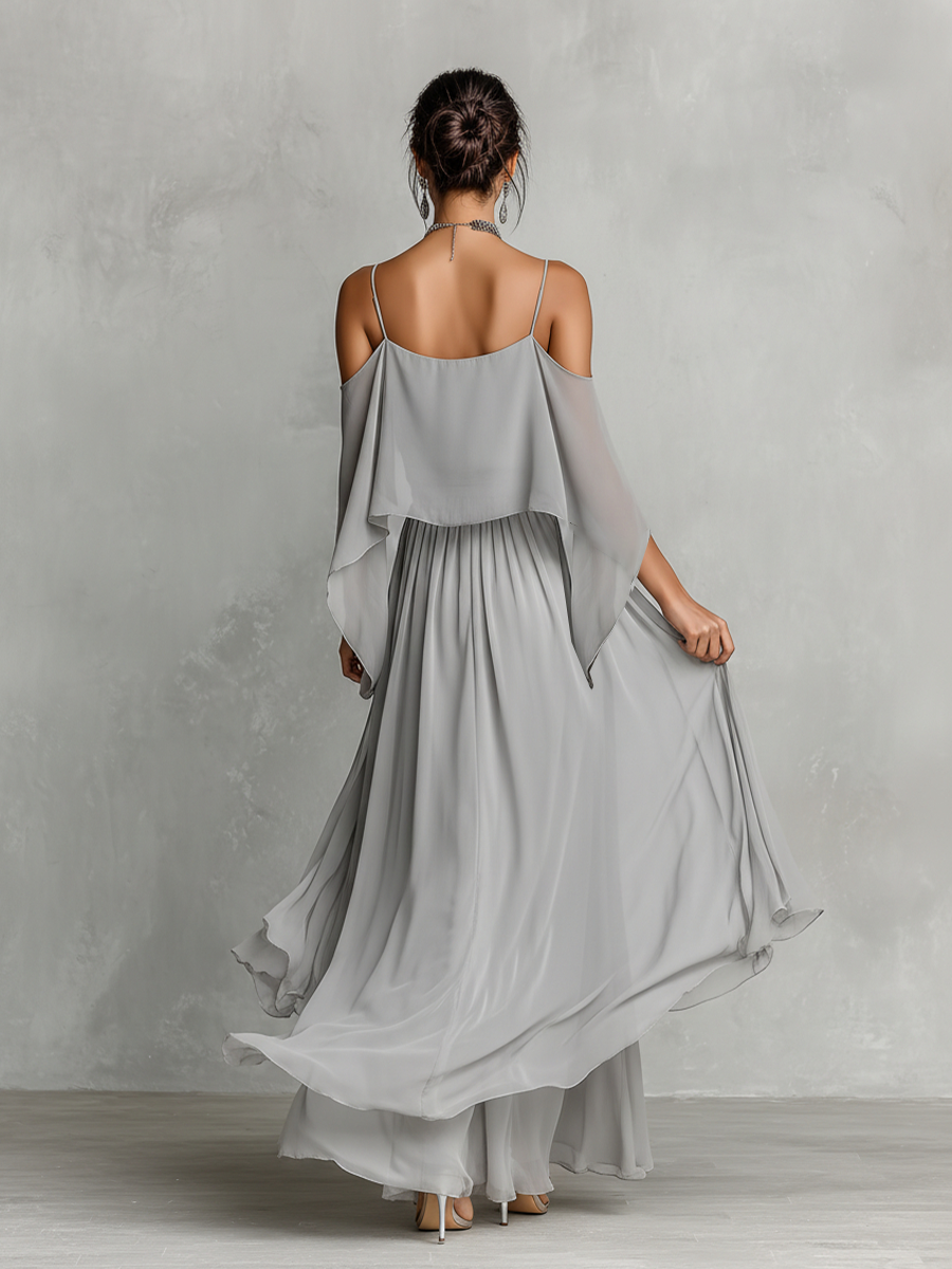 Green - A model wears a floor-length grey chiffon maxi dress featuring delicate spaghetti straps, a draped cold-shoulder overlay, a ruched waist, and a layered, flowing skirt.