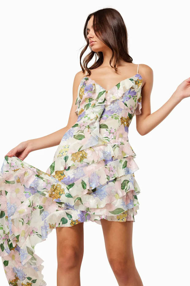 Green - A model wearing a sleeveless maxi dress in a pastel floral print chiffon, featuring cascading ruffles, a V-neckline, and an asymmetric hem with a train.