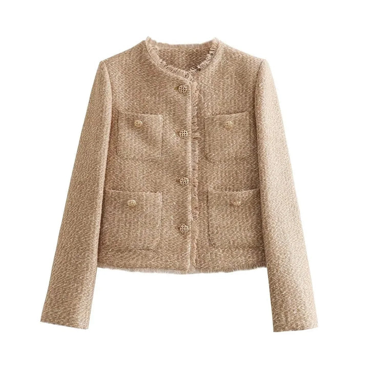 Beige - A woman wearing a beige textured boucle cropped jacket with gold buttons and fringed edges, styled over a light blue ruffled blouse and high-waisted jeans.