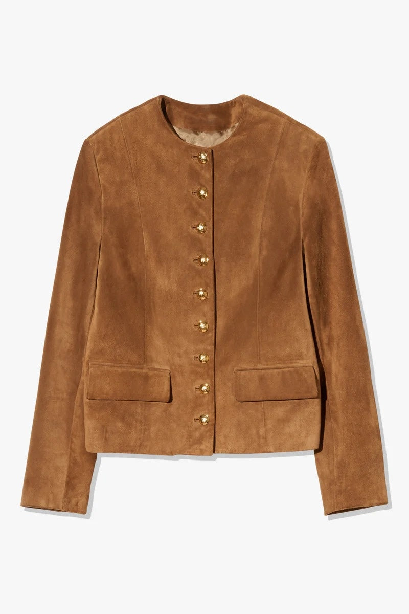 Brown - A woman wearing a tan, collarless suede cropped jacket with gold-tone buttons over a black top and trousers.