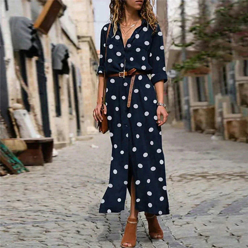 Navy Blue - Woman walking outdoors wearing a long polka dot button-front shirt dress with long sleeves and chest pockets