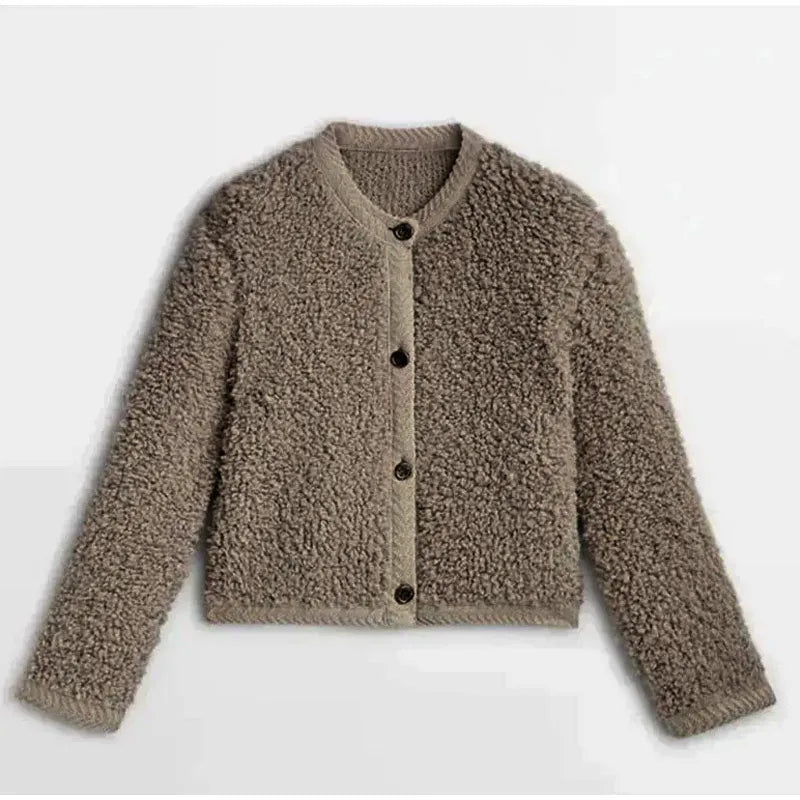 Brown - A woman wearing a beige, textured boucle knit cardigan with a button-front closure, ribbed trims, and gold-tone buttons, styled casually over a white top and light blue jeans.