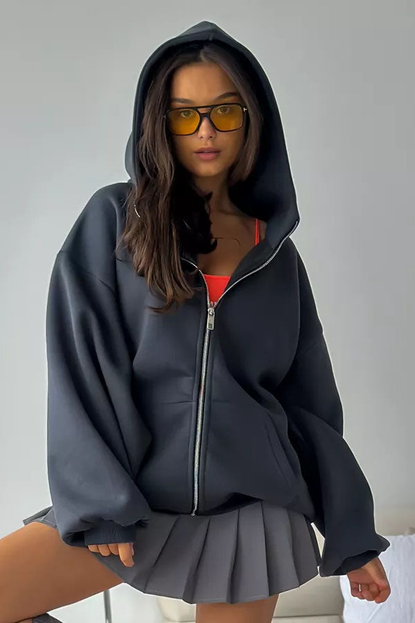 Black - Back view of a woman wearing a dark grey oversized hoodie featuring a large graphic print of an angel statue and white doves, paired with a dark grey pleated mini skirt.