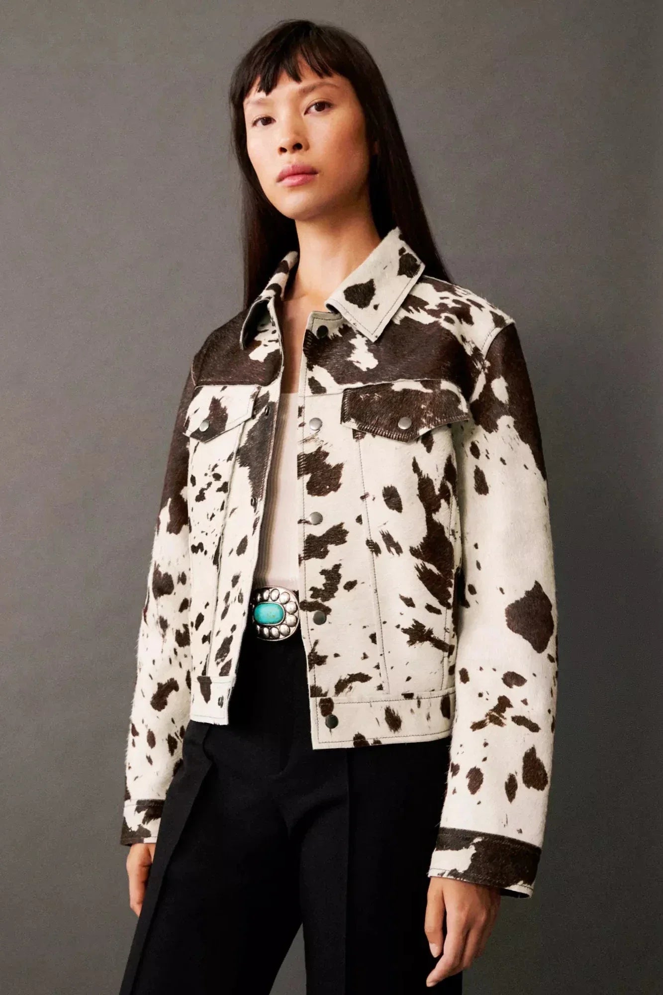 Dairy Cow - Women's cropped button-front jacket featuring a bold cow print pattern, pointed collar, and chest flap pockets.