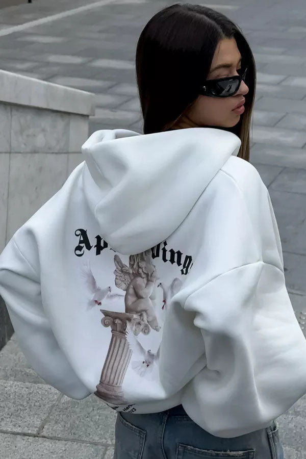 White - Back view of a woman wearing a dark grey oversized hoodie featuring a large graphic print of an angel statue and white doves, paired with a dark grey pleated mini skirt.