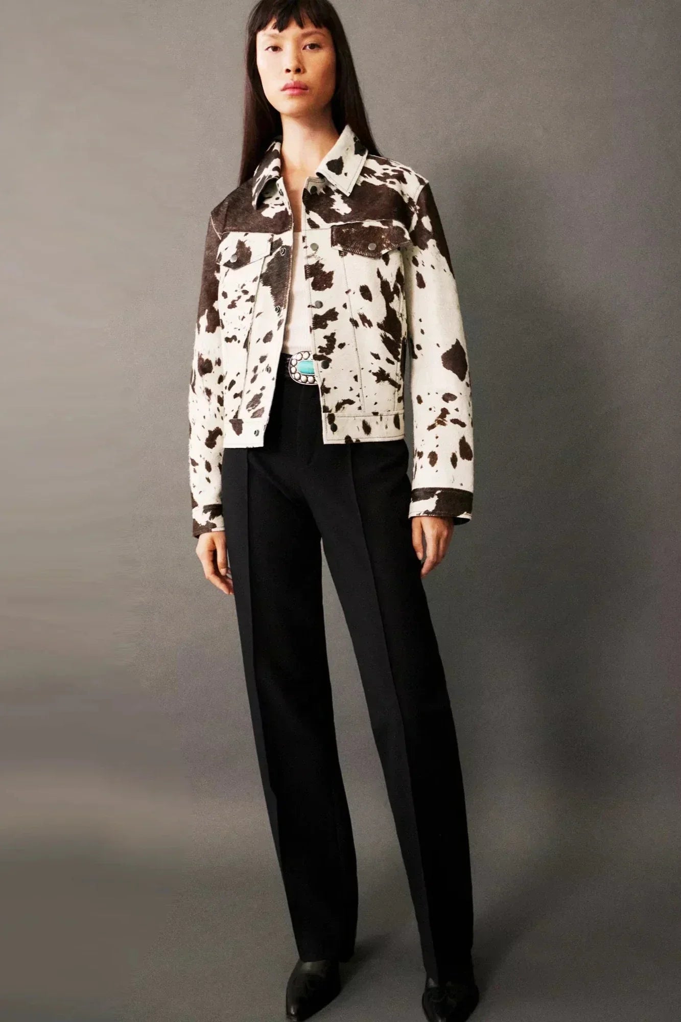 Dairy Cow - Women's cropped button-front jacket featuring a bold cow print pattern, pointed collar, and chest flap pockets.
