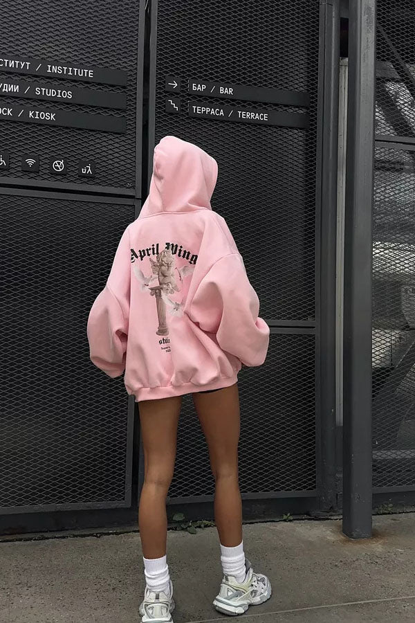 White - Back view of a woman wearing a dark grey oversized hoodie featuring a large graphic print of an angel statue and white doves, paired with a dark grey pleated mini skirt.