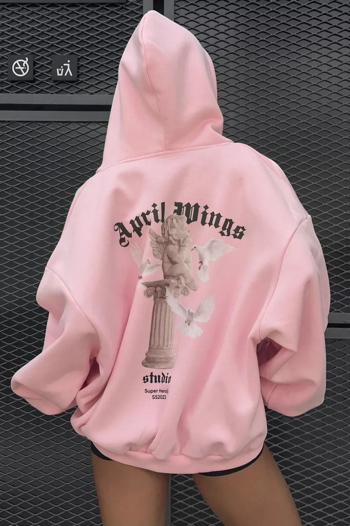 Pink - Back view of a woman wearing a dark grey oversized hoodie featuring a large graphic print of an angel statue and white doves, paired with a dark grey pleated mini skirt.