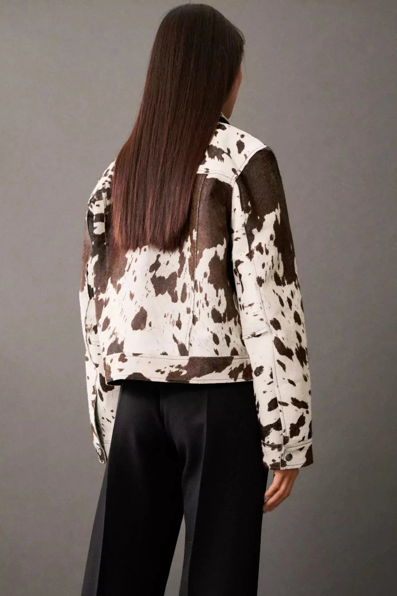 Dairy Cow - Women's cropped button-front jacket featuring a bold cow print pattern, pointed collar, and chest flap pockets.