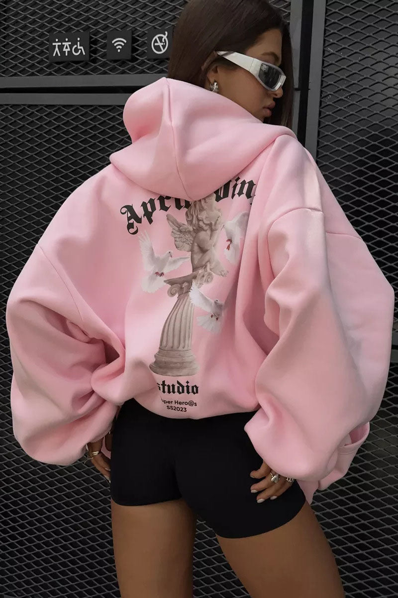 Pink - Back view of a woman wearing a dark grey oversized hoodie featuring a large graphic print of an angel statue and white doves, paired with a dark grey pleated mini skirt.