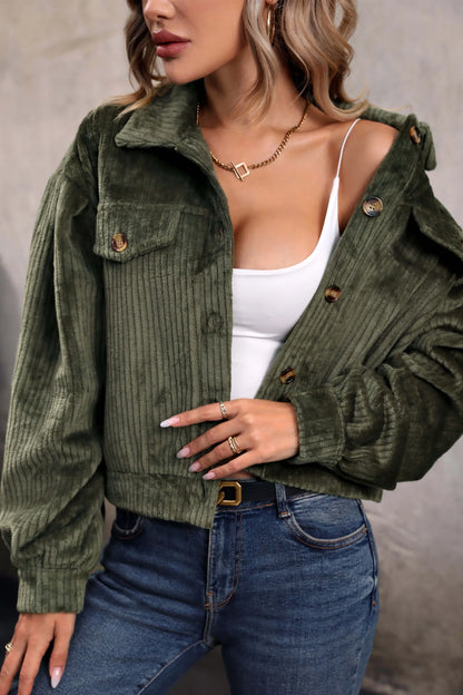 Olive - Woman wearing a green corduroy cropped jacket with button front and chest pockets, styled with a white crop top and jeans.