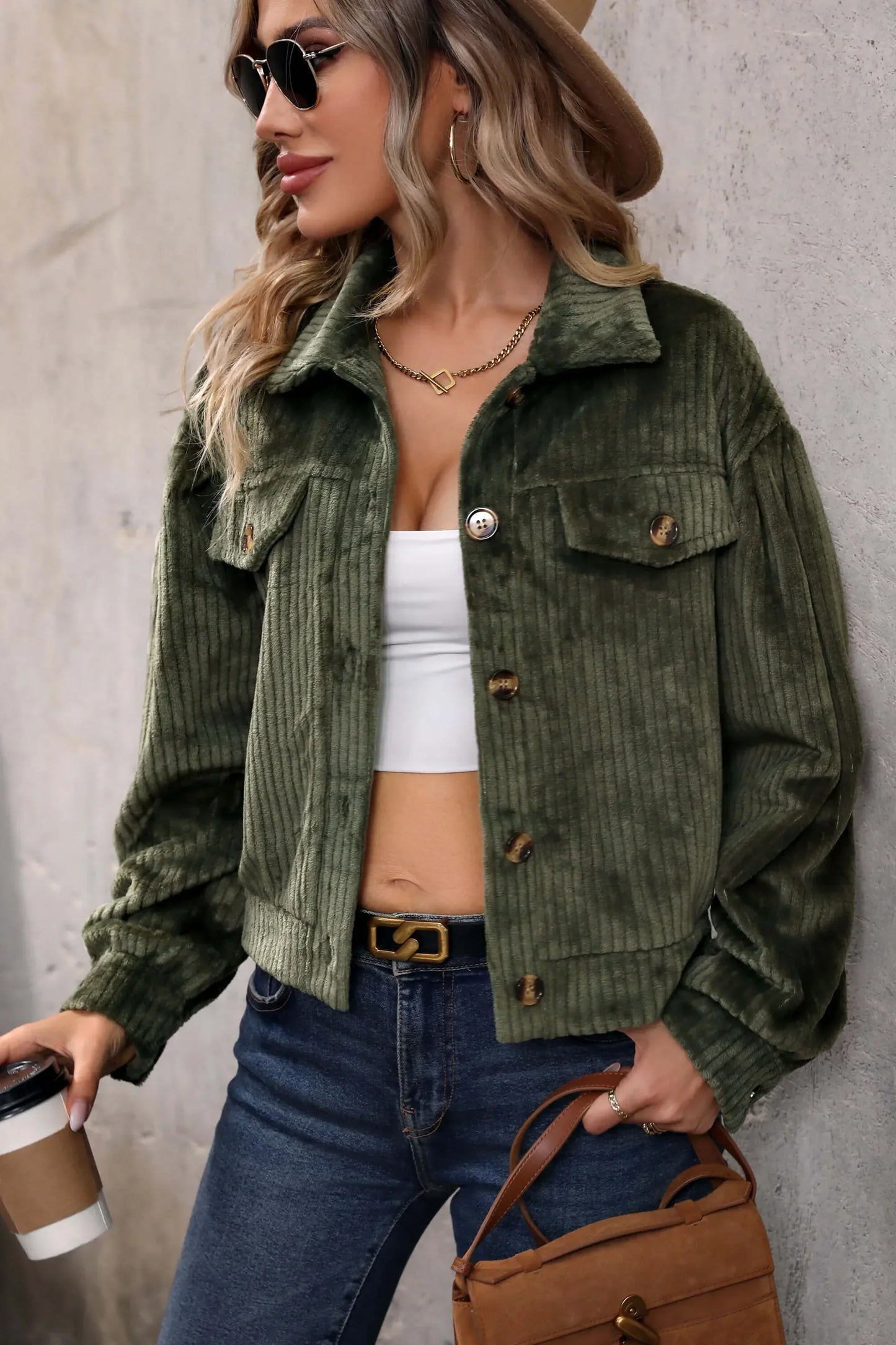 Olive - Woman wearing a green corduroy cropped jacket with button front and chest pockets, styled with a white crop top and jeans.