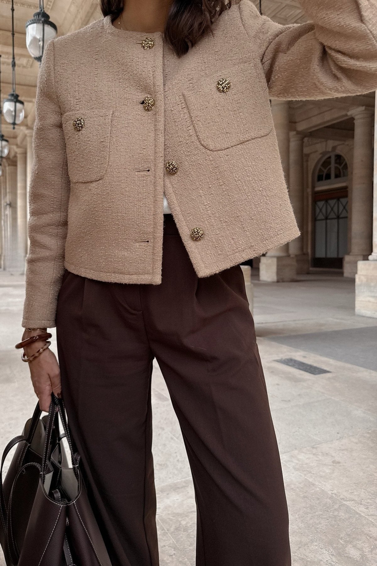 Khaki - Women's smart casual textured cropped jacket in a neutral tone, featuring ornate buttons and a collarless design, styled over a white t-shirt and denim shorts.