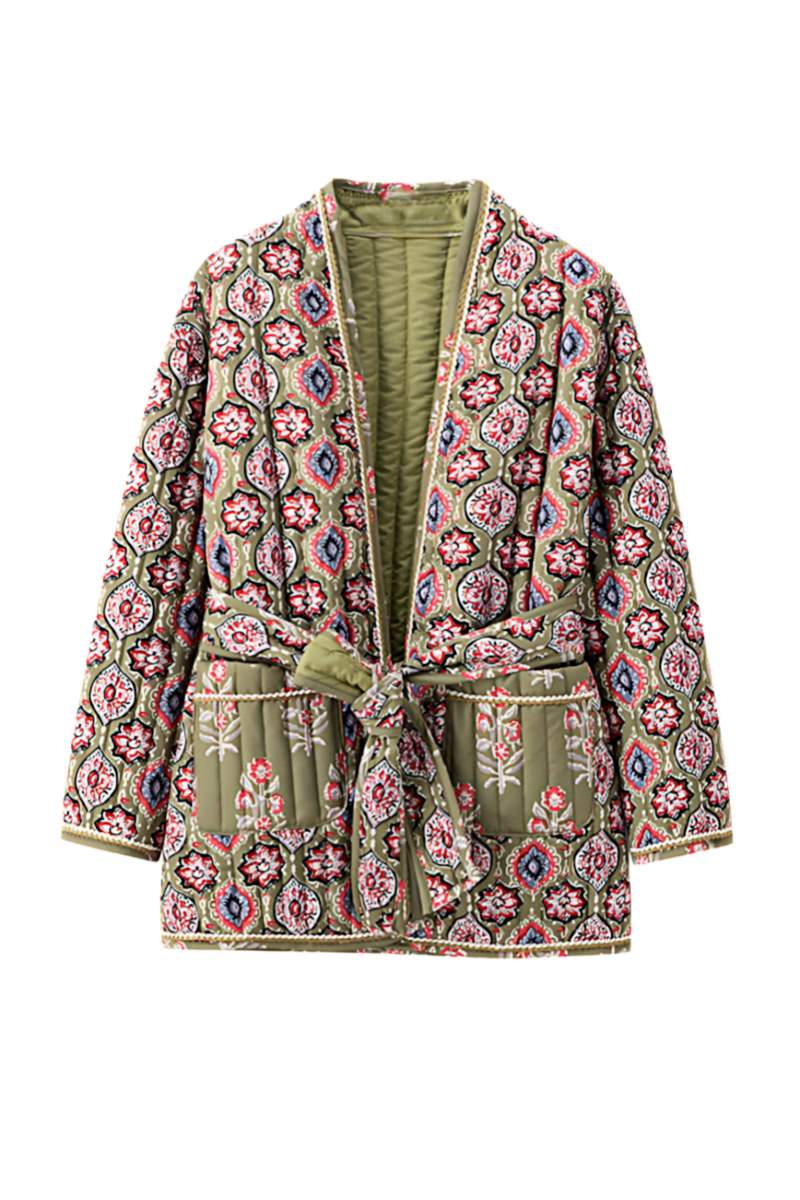Multicolor - Woman in a cafe wearing an open-front quilted jacket with a colourful geometric medallion print over a black tank top and dark denim jeans.