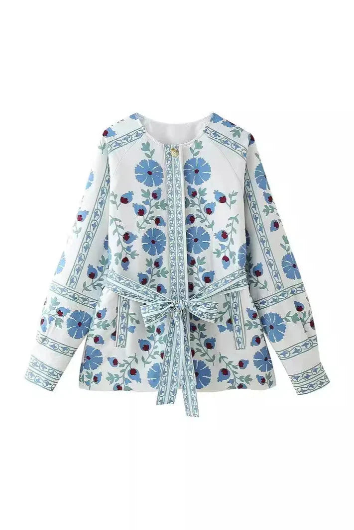 Blue - Women's cream mid-length jacket featuring blue and burgundy floral embroidery, a matching tie-waist belt, and button-front closure, styled over denim.