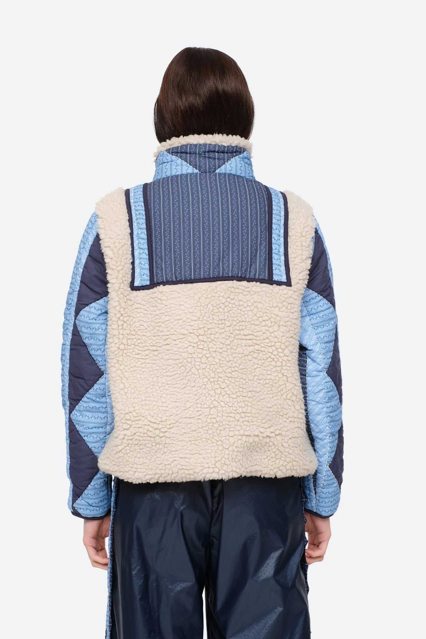 XL - Women's heavyweight pullover jacket featuring a cream fleece bodice, a high snap-button collar, and contrasting blue quilted sleeves with a geometric patchwork print.
