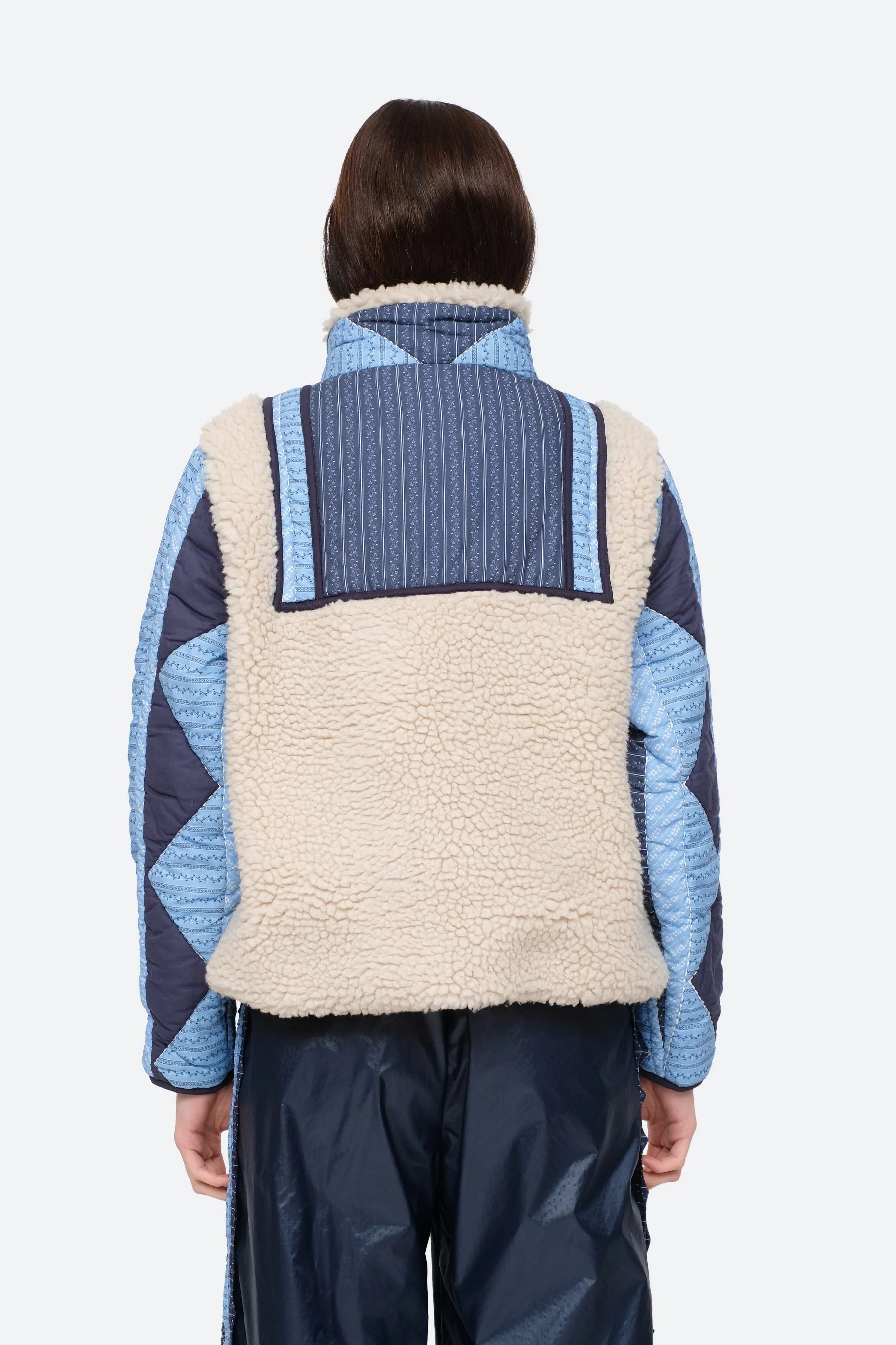 XL - Women's heavyweight pullover jacket featuring a cream fleece bodice, a high snap-button collar, and contrasting blue quilted sleeves with a geometric patchwork print.