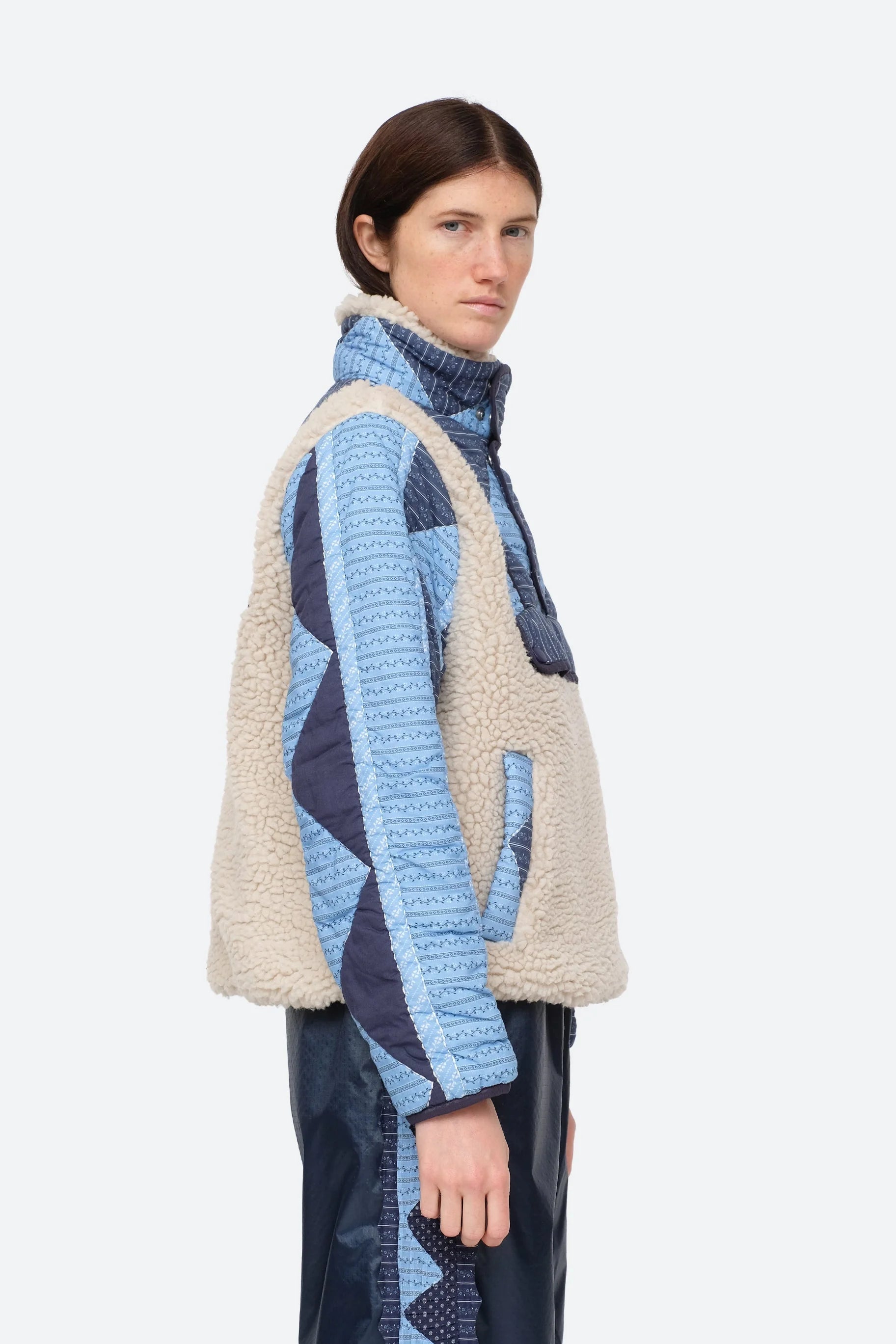 XL - Women's heavyweight pullover jacket featuring a cream fleece bodice, a high snap-button collar, and contrasting blue quilted sleeves with a geometric patchwork print.