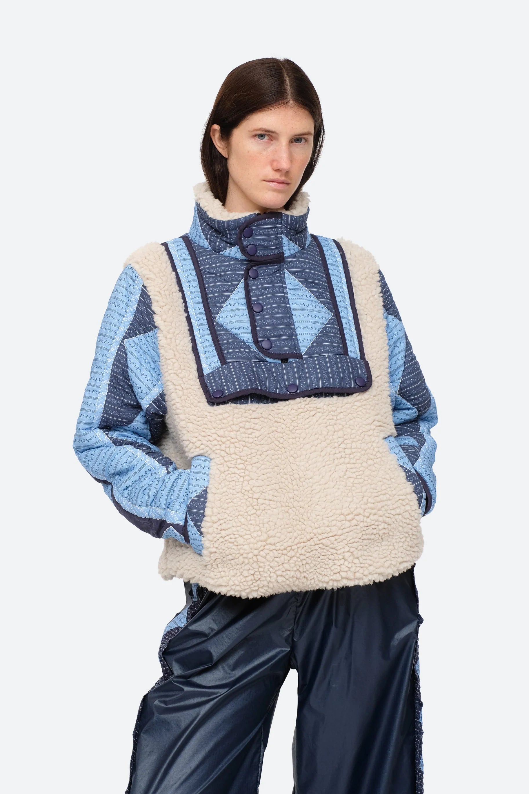 XL - Women's heavyweight pullover jacket featuring a cream fleece bodice, a high snap-button collar, and contrasting blue quilted sleeves with a geometric patchwork print.