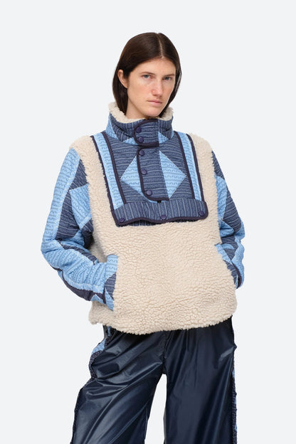 XL - Women's heavyweight pullover jacket featuring a cream fleece bodice, a high snap-button collar, and contrasting blue quilted sleeves with a geometric patchwork print.