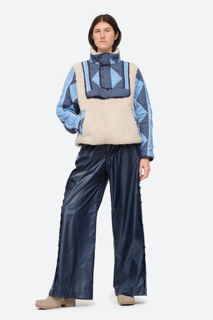 XL - Women's heavyweight pullover jacket featuring a cream fleece bodice, a high snap-button collar, and contrasting blue quilted sleeves with a geometric patchwork print.