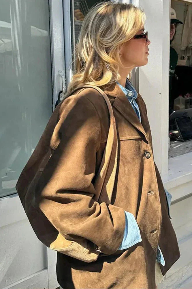 Ligh Brown - Woman wearing a brown longline suede-look jacket over a denim shirt outdoors.