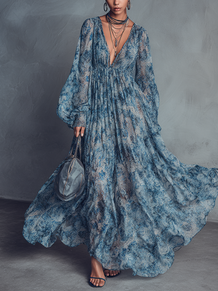 Blue - A model wearing a floor-length, long-sleeved maxi dress in a blue and grey abstract print chiffon, featuring a deep plunging V-neckline and voluminous balloon sleeves.
