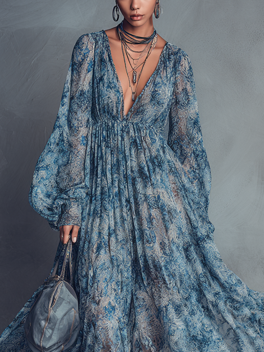 Blue - A model wearing a floor-length, long-sleeved maxi dress in a blue and grey abstract print chiffon, featuring a deep plunging V-neckline and voluminous balloon sleeves.