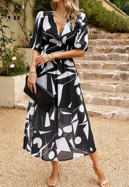 Blue - Women's flowing midi dress featuring a V-neckline, half puff sleeves, and a large-scale abstract floral print in muted earthy tones, styled with a woven clutch.