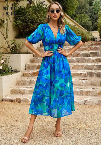 Blue - Women's flowing midi dress featuring a V-neckline, half puff sleeves, and a large-scale abstract floral print in muted earthy tones, styled with a woven clutch.