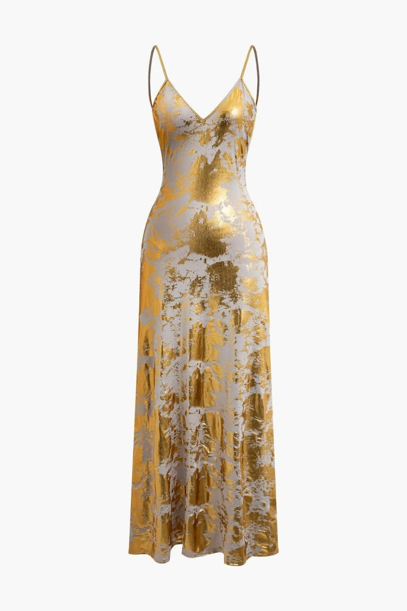 Gold - A woman wearing a sleeveless, floor-length satin slip dress with a gold and cream abstract print, featuring a V-neckline and thin straps.