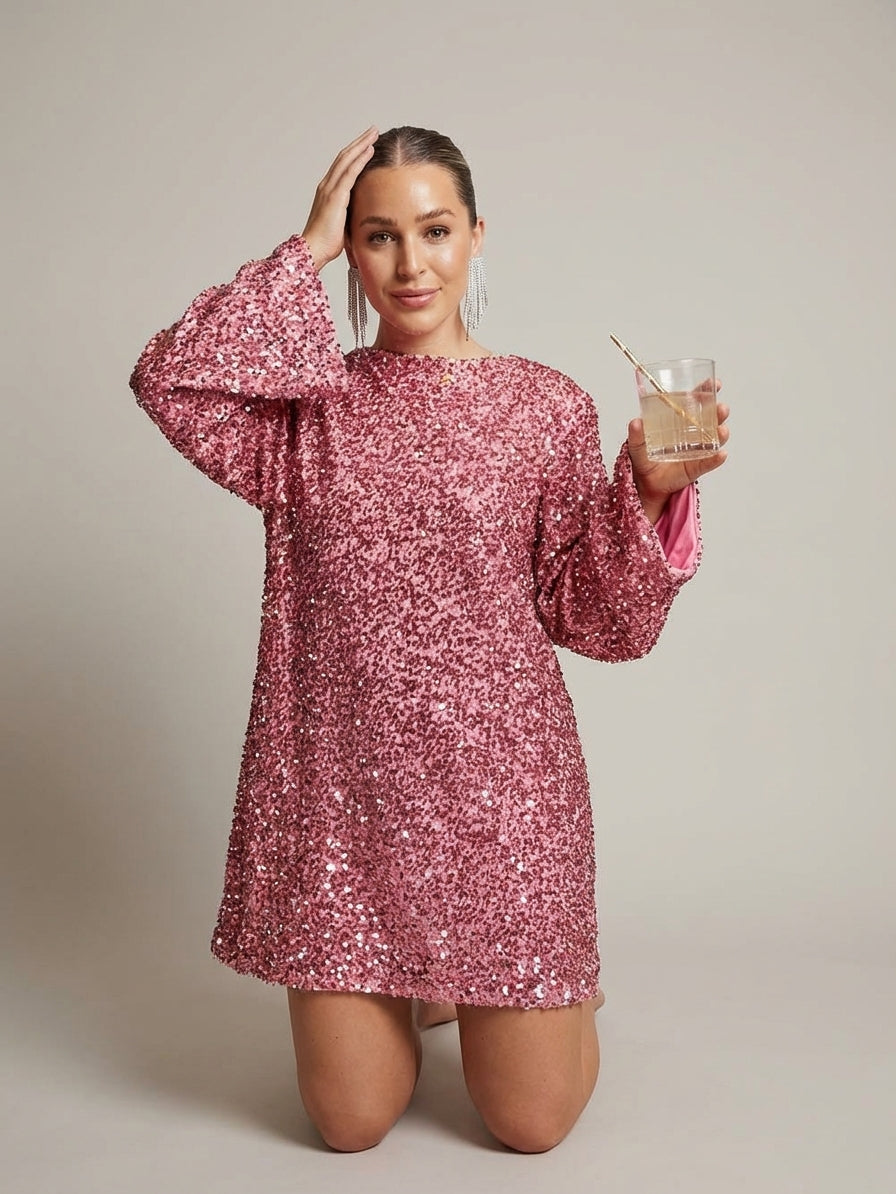 Pink - Model wearing a cream-coloured, highly textured bouclé knit mini dress with a high neckline, long sleeves, and an A-line silhouette, paired with black pointed-toe heels.