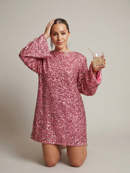 Pink - Model wearing a cream-coloured, highly textured bouclé knit mini dress with a high neckline, long sleeves, and an A-line silhouette, paired with black pointed-toe heels.