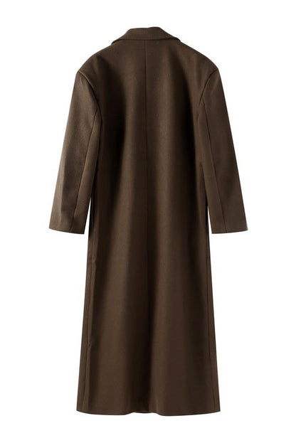 Brown - A person wearing a longline, double-breasted dark chocolate brown overcoat with notch lapels, styled over a beige knit sweater and cream silk skirt.