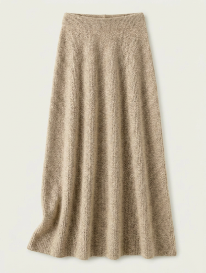 A woman wearing a grey brushed knit longline cardigan with a matching turtleneck and skirt, showcasing a minimalist, monochromatic look.