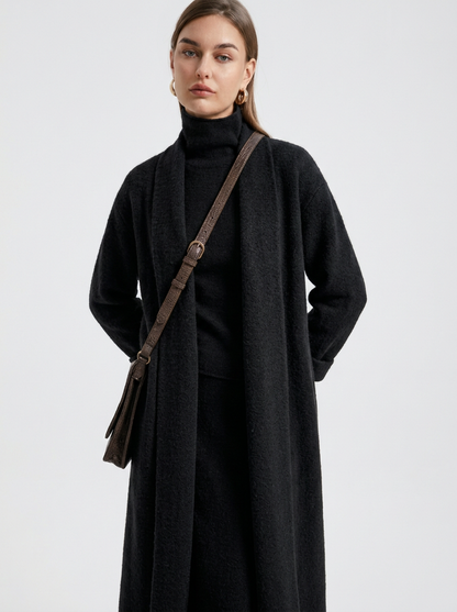 A woman wearing a grey brushed knit longline cardigan with a matching turtleneck and skirt, showcasing a minimalist, monochromatic look.