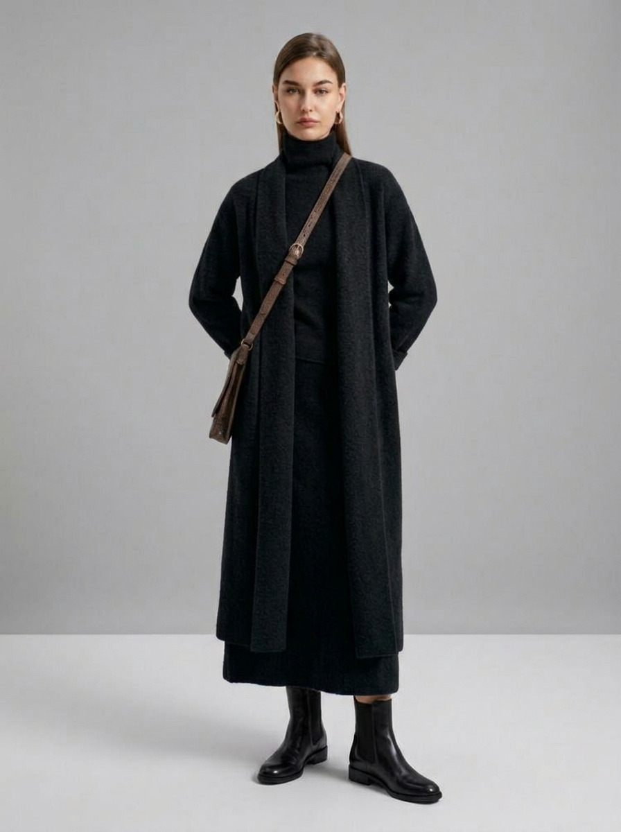 A woman wearing a grey brushed knit longline cardigan with a matching turtleneck and skirt, showcasing a minimalist, monochromatic look.