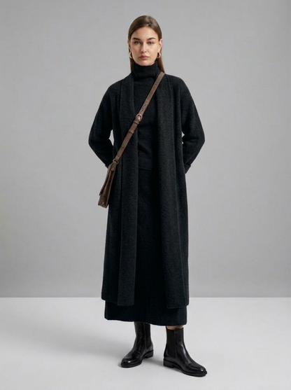 A woman wearing a grey brushed knit longline cardigan with a matching turtleneck and skirt, showcasing a minimalist, monochromatic look.
