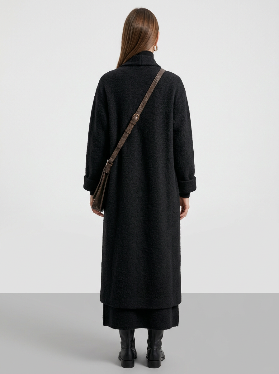 A woman wearing a grey brushed knit longline cardigan with a matching turtleneck and skirt, showcasing a minimalist, monochromatic look.