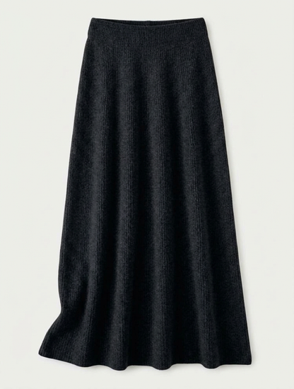 A woman wearing a grey brushed knit longline cardigan with a matching turtleneck and skirt, showcasing a minimalist, monochromatic look.