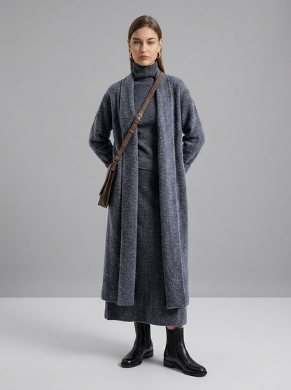 A woman wearing a grey brushed knit longline cardigan with a matching turtleneck and skirt, showcasing a minimalist, monochromatic look.