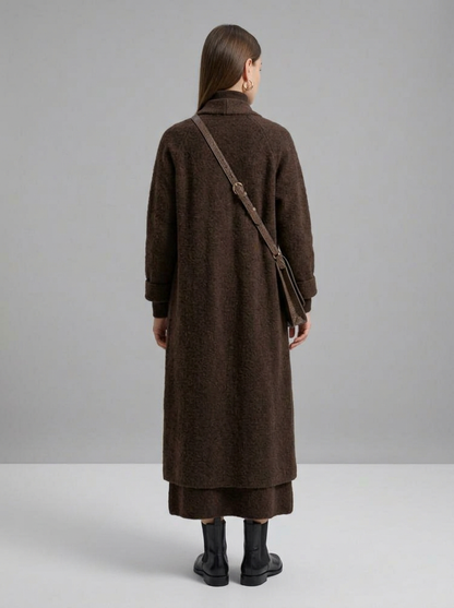 A woman wearing a grey brushed knit longline cardigan with a matching turtleneck and skirt, showcasing a minimalist, monochromatic look.