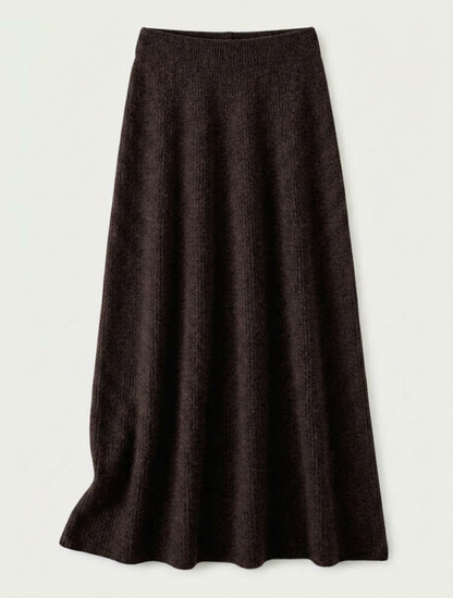 A woman wearing a grey brushed knit longline cardigan with a matching turtleneck and skirt, showcasing a minimalist, monochromatic look.