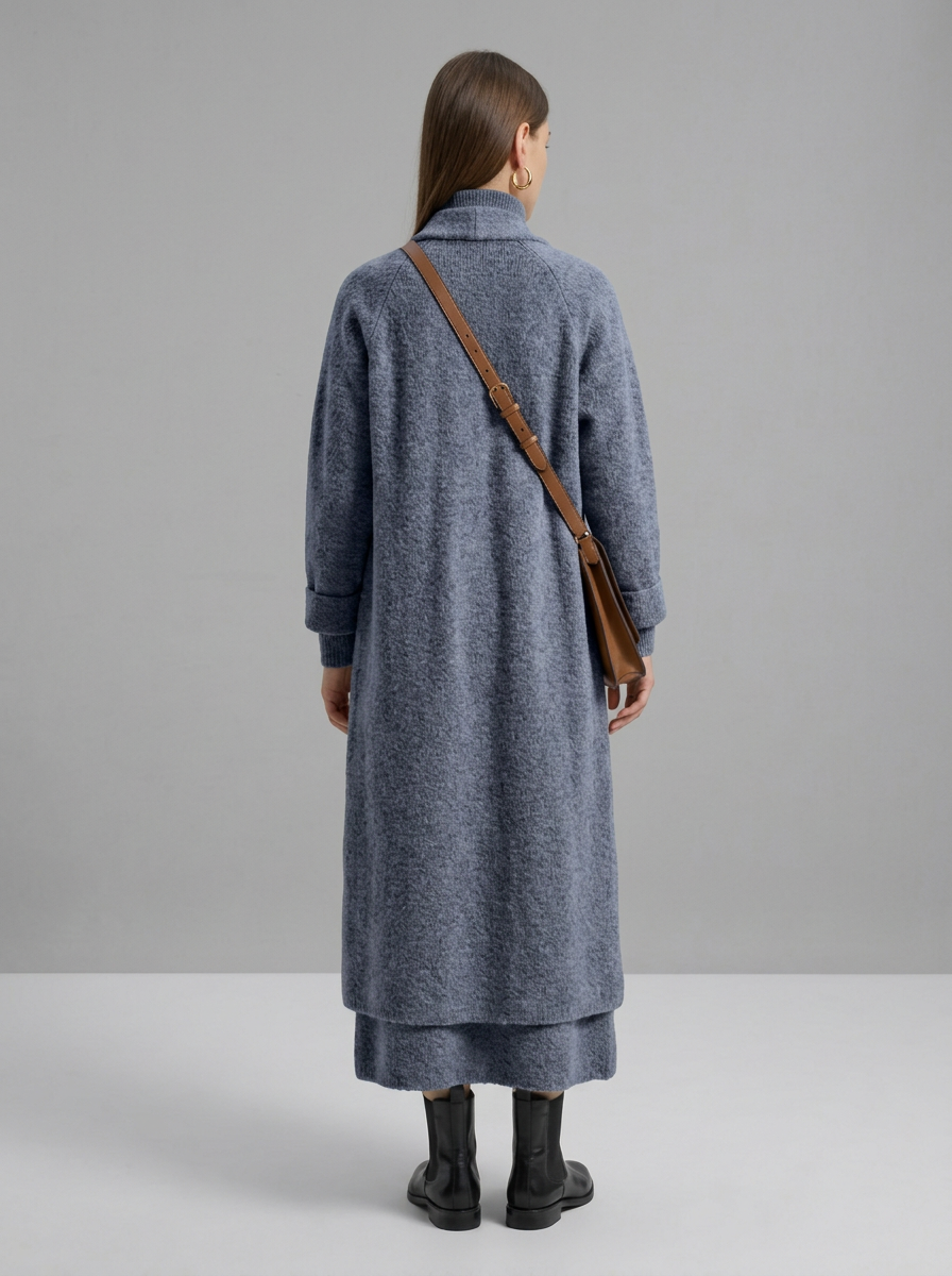A woman wearing a grey brushed knit longline cardigan with a matching turtleneck and skirt, showcasing a minimalist, monochromatic look.