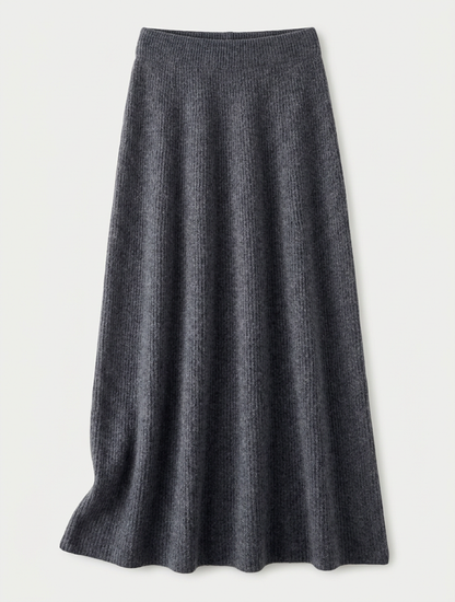 A woman wearing a grey brushed knit longline cardigan with a matching turtleneck and skirt, showcasing a minimalist, monochromatic look.