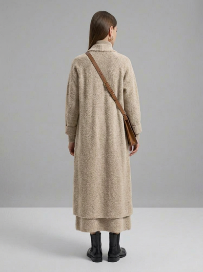 A woman wearing a grey brushed knit longline cardigan with a matching turtleneck and skirt, showcasing a minimalist, monochromatic look.