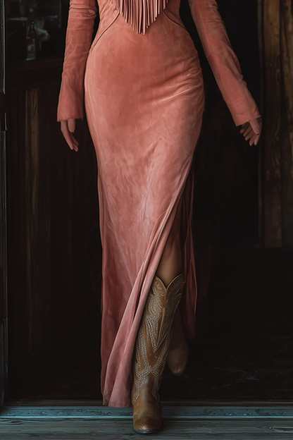 Pink - A woman wearing a dusty rose brushed suede maxi dress featuring western-style embroidery, a V-shaped fringe yoke, long sleeves, and a high leg slit, paired with embroidered cowboy boots.