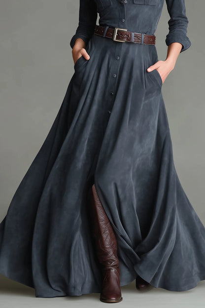 Blue - A woman wearing a slate grey brushed-texture maxi shirt dress with a collar, button-down front, chest utility pockets, a brown leather belt, and tall brown leather boots.