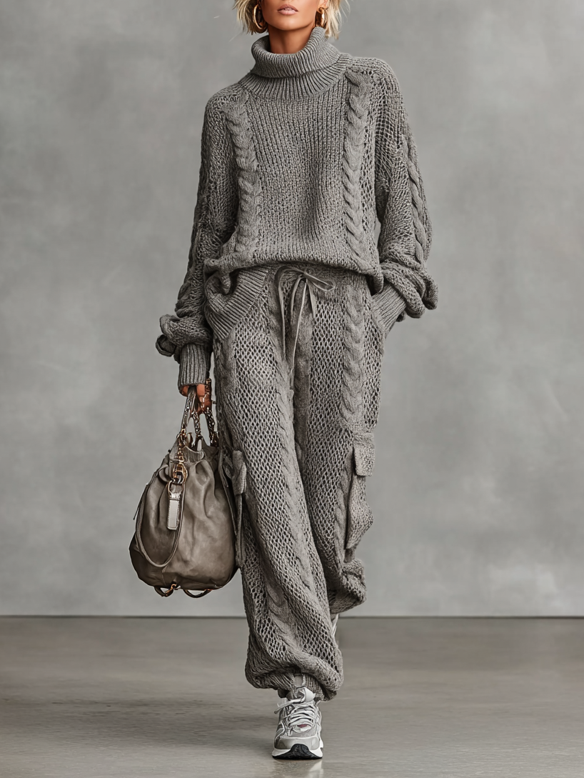 Gray - A woman wearing a matching grey cable knit two-piece set featuring a roll neck jumper and relaxed-fit cargo trousers with a drawstring waist.