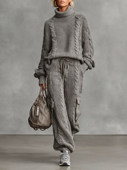 Gray - A woman wearing a matching grey cable knit two-piece set featuring a roll neck jumper and relaxed-fit cargo trousers with a drawstring waist.